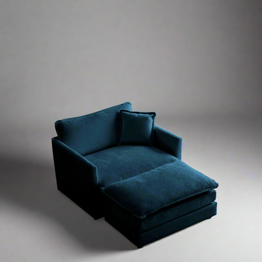 A blue chenille cushioned club chair with an ottoman, placed against a neutral background.